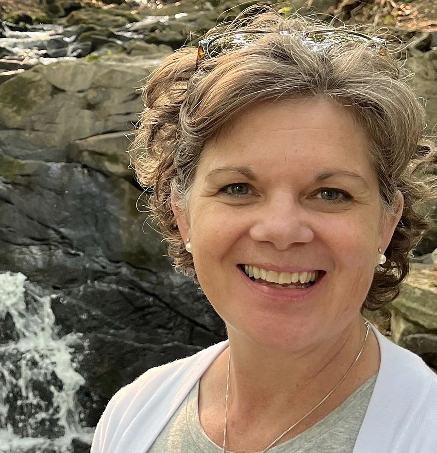 Erika Murphy smiling outdoors beside a waterfall.